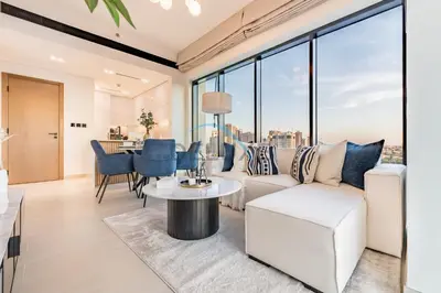 a living room with a white couch and a table at City Views 1BR Close to Golf Course & Attractions, Binghatti Venus, Jumeirah Village Circle by Deluxe Holiday Homes in Dubai