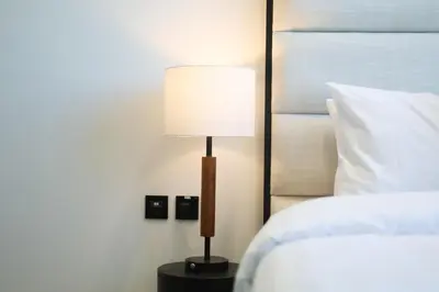 a lamp sitting on a table next to a bed at Cosy Studio in Binghatti House in Dubai