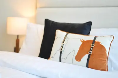 a pillow with a horse on it sitting on a bed at Cosy Studio in Binghatti House in Dubai