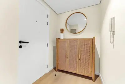 a hallway with a mirror and a wooden cabinet at Waves - Modern Studio with Stunning Lake Views in JLT in Dubai