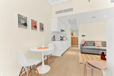 a living room with a table and chairs and a couch at Waves - Modern Studio with Stunning Lake Views in JLT in Dubai