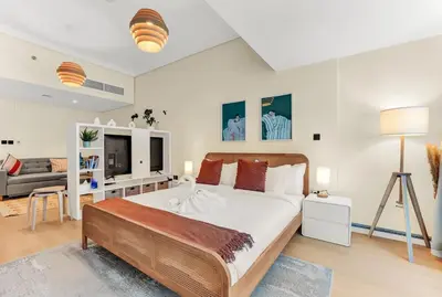 a bedroom with a large bed and a couch at Waves - Modern Studio with Stunning Lake Views in JLT in Dubai