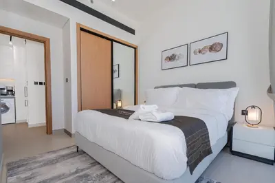 a bedroom with a large bed with white sheets at Escape24 Modern 1BR Balcony with City View in Dubai