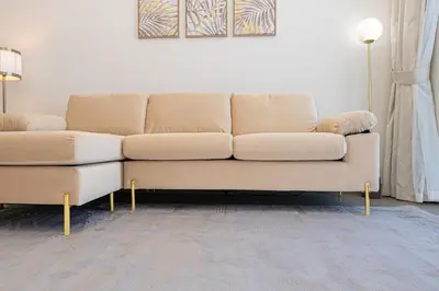 a tan couch in a living room with a couch at Escape24 Modern 1BR Balcony with City View in Dubai