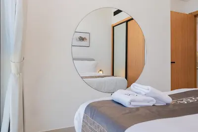 a room with two beds and a mirror at Escape24 Modern 1BR Balcony with City View in Dubai