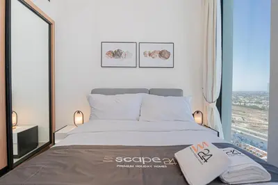 a bedroom with a bed and a large window at Escape24 Modern 1BR Balcony with City View in Dubai