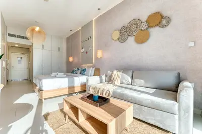 a living room with a couch and a bed at Starfish Palm Views Studio in Dubai
