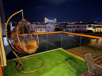 a hammock on a balcony at night at Octopus - Iconic Palm Studio With Views in Dubai