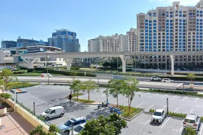 a parking lot with parked cars in a city at Octopus - Iconic Palm Studio With Views in Dubai