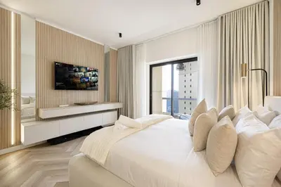 a white bedroom with a large bed and a window at Daniels 1BR at Sadaf JBR in Dubai