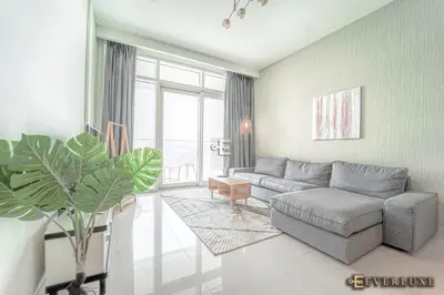 a living room with a couch and a plant at Chill 1br W Beach Views & Private Beach Access in Dubai