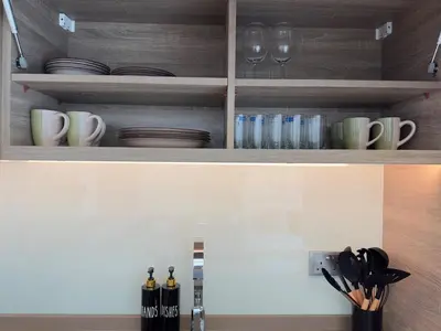 a kitchen with wooden cabinets with glasses and utensils at Luxueux Ammenities Tower, Sea View, Near to Beach in Dubai