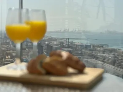 a table with two glasses of orange juice and a pastry at Luxueux Ammenities Tower, Sea View, Near to Beach in Dubai