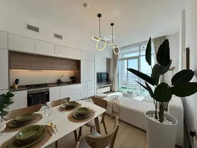 a kitchen and living room with a table and a couch at Luxueux Ammenities Tower, Sea View, Near to Beach in Dubai