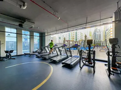 a man in a gym with treadmills and machines at Luxueux Ammenities Tower, Sea View, Near to Beach in Dubai