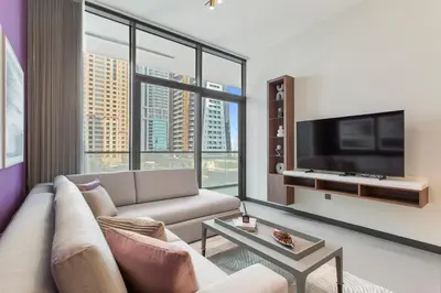 a living room with a couch and a tv at High End 1 Bedroom with Exquisite Layout in JLT in Dubai