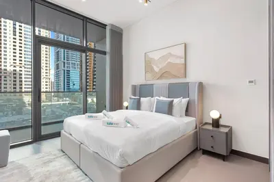 a bedroom with a large bed with a large window at High End 1 Bedroom with Exquisite Layout in JLT in Dubai