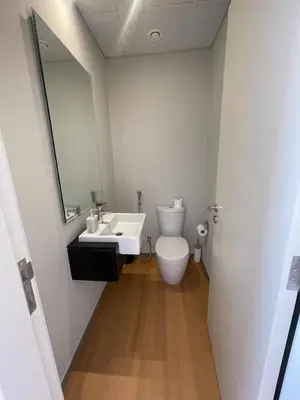 a bathroom with a toilet and a sink and a mirror at 014 - Damac Hills in Dubai