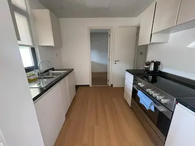 a kitchen with white cabinets and black counter tops at 014 - Damac Hills in Dubai