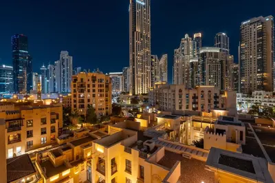 a city skyline at night with tall buildings at GuestReady - Downtown retreat with city views in Dubai