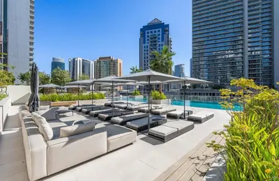 a patio with couches and umbrellas and a pool at Luxury Apt with Full Burj Khalifa Skyline Views in Dubai