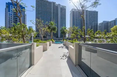 a walkway in the middle of a city with tall buildings at Luxury Apt with Full Burj Khalifa Skyline Views in Dubai