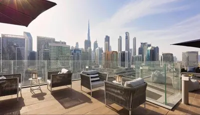 a rooftop patio with a view of a city skyline at Water Front Apartment, Burj Khalifa Views in Dubai