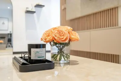 a vase with a orange rose sitting on a table at Water Front Apartment, Burj Khalifa Views in Dubai