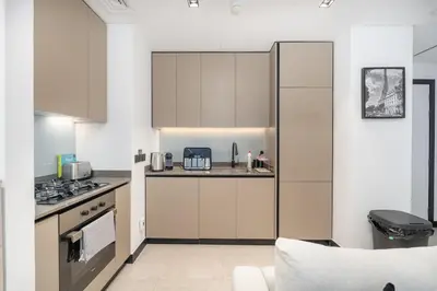 a kitchen with white cabinets and a stove top oven at Water Front Apartment, Burj Khalifa Views in Dubai