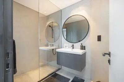 a bathroom with a sink and two mirrors at Water Front Apartment, Burj Khalifa Views in Dubai