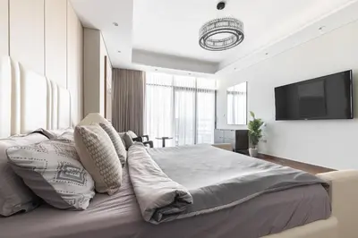 a bedroom with a large bed with a flat screen tv at SIMPLY COMFORT Apartments at Nobles Tower Luxury Burj View in Dubai