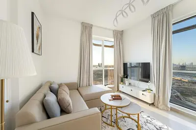 a living room with a couch and a large window at Luxury 1BR with Lake View Near Downtown Balcony and Pool Access in Dubai