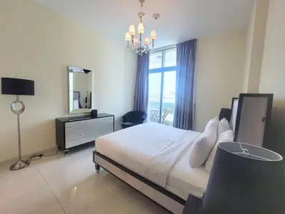 a bedroom with a bed and a dresser and a mirror at Polo Residence C1 - Blue Ocean Holiday Homes in Dubai