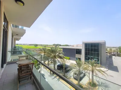 a balcony with palm trees and a building at Polo Residence C1 - Blue Ocean Holiday Homes in Dubai