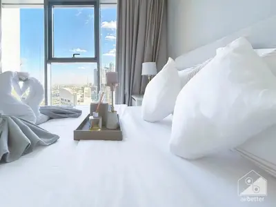 a white bed with white pillows and a window at Luxurious Burj Royale 1B Apt With Balcony & City Views in Dubai