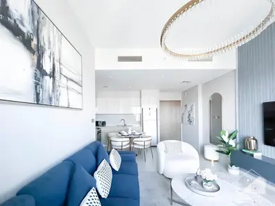 a living room with a blue couch and a table at Luxurious Burj Royale 1B Apt With Balcony & City Views in Dubai