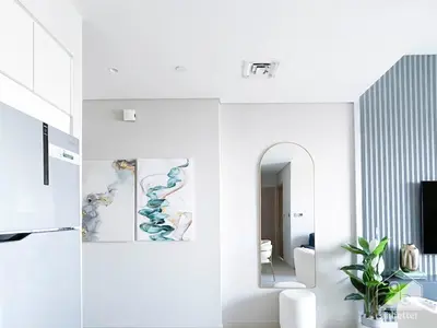 a living room with white walls and a mirror at Luxurious Burj Royale 1B Apt With Balcony & City Views in Dubai