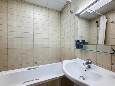 a bathroom with a sink and a tub and a mirror at Marina 1 Bedroom Gem in Dubai