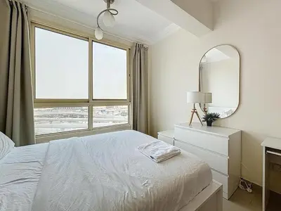 a white bedroom with a bed and a mirror at Marina 1 Bedroom Gem in Dubai