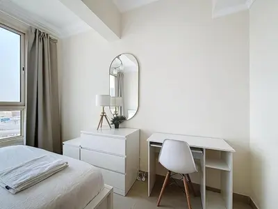 a white bedroom with a desk and a mirror at Marina 1 Bedroom Gem in Dubai