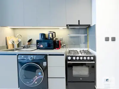 a kitchen with a stove and a dishwasher at Tranquil Studio Getaway in Dubai's MAG 920 in Dubai