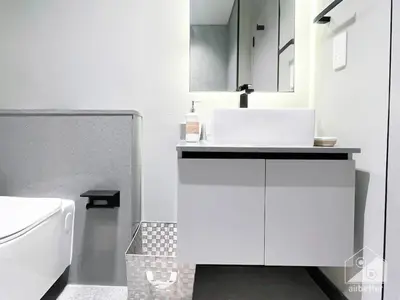 a white bathroom with a sink and a toilet at Tranquil Studio Getaway in Dubai's MAG 920 in Dubai