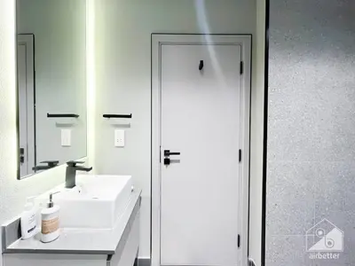 a white bathroom with a sink and a mirror at Stylish Studio Getaway in Dubai's MAG 920 in Dubai