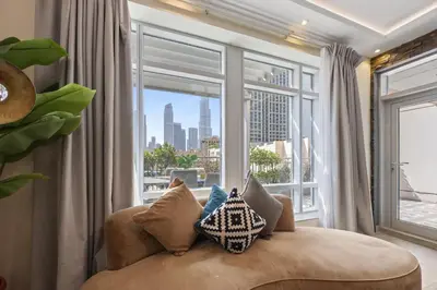 a living room with a couch and a large window at Burj Khalifa View Apartment with Balcony Downtown Dubai in Dubai