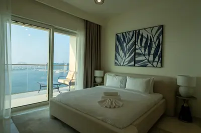 a bedroom with a large bed and a large window at Homes & Beyond I Pristine 2BR with Waterfront view in Dubai