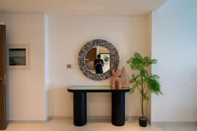a table with a mirror and a man taking a picture at Homes & Beyond I Pristine 2BR with Waterfront view in Dubai