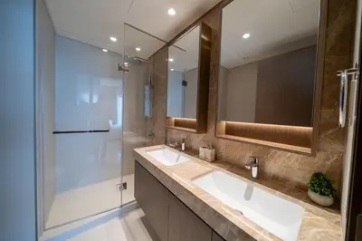 a bathroom with two sinks and a shower at Homes & Beyond I Pristine 2BR with Waterfront view in Dubai