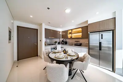 a kitchen and dining room with a table and chairs at Homes Beyond I Stunning Oceanfront 2 BR Apartment in Dubai