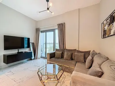 a living room with a couch and a flat screen tv at Family friendly 2-bedroom in Dubai