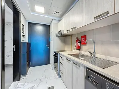 a kitchen with a sink and a blue door at Family friendly 2-bedroom in Dubai